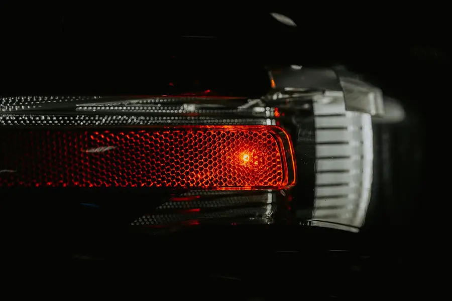 Close-up of a glowing red lamp on a dark car